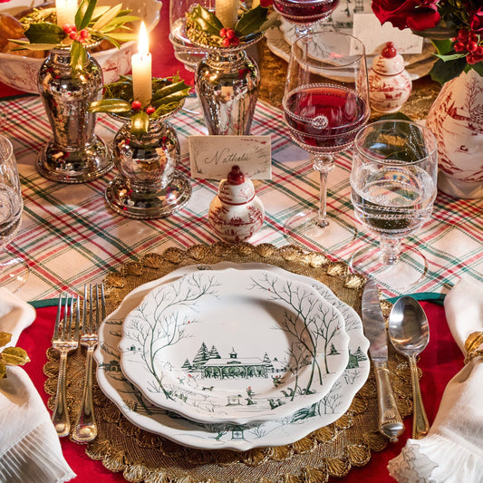 Decorative Christmas table setting with plaid tablecloth, candles, and festive decorations.