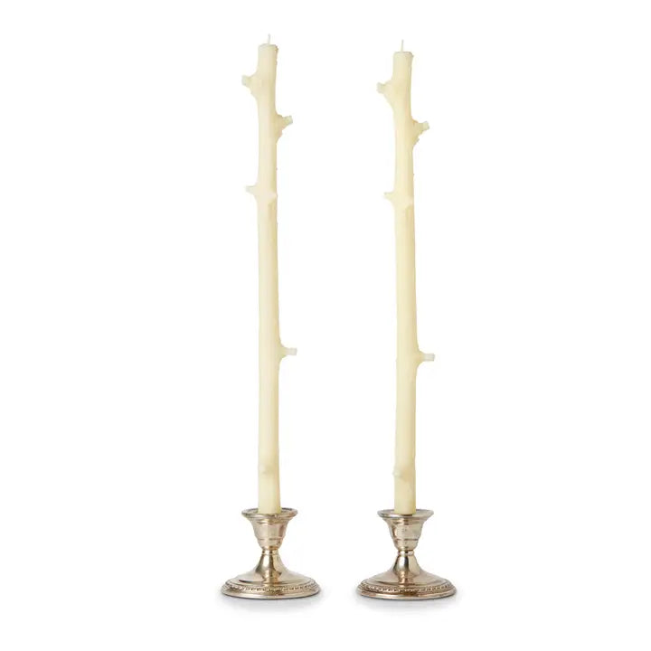 Two off-white twig candle holders with silver bases on a white background