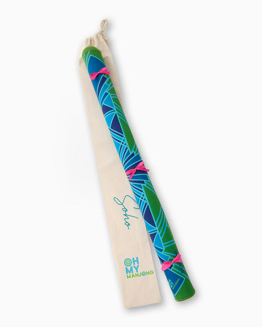 Colorful blue and green mahjong mat rolled and tied up laying on its canvas duster bag.