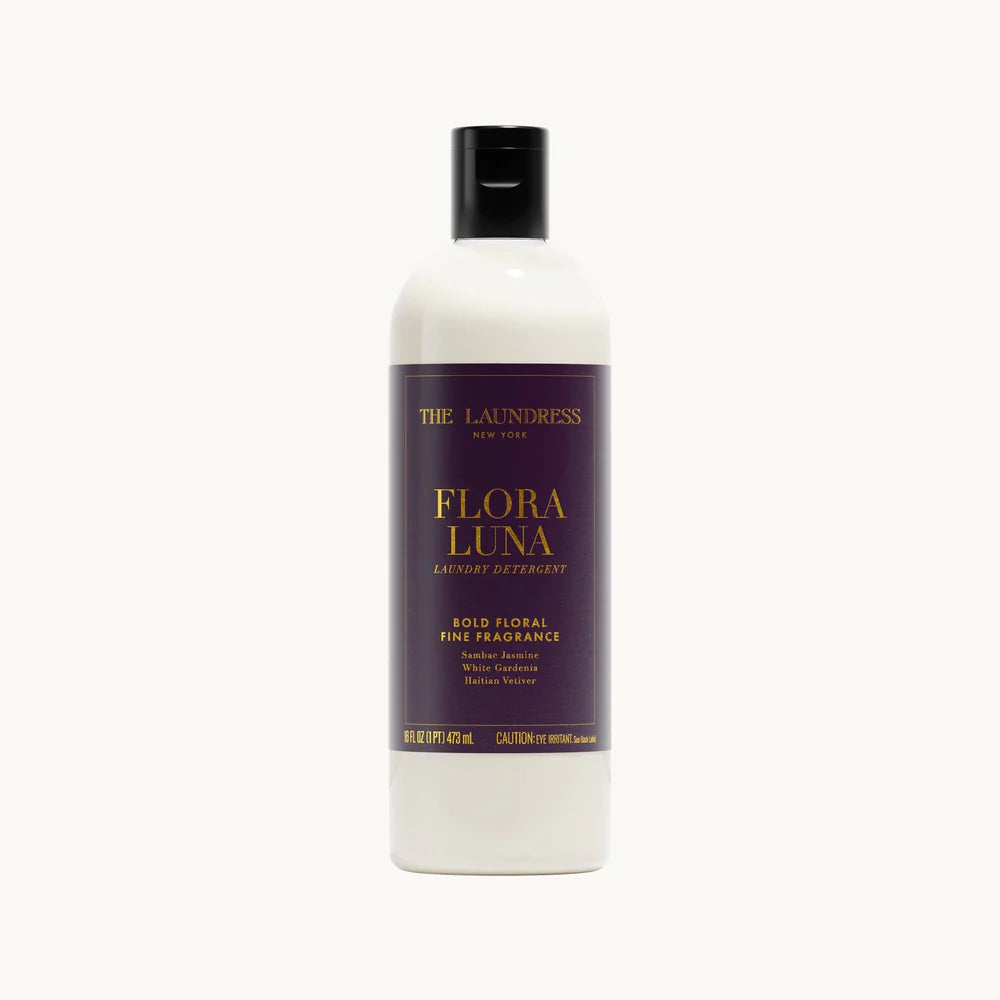 Clear bottle with deep purple and gold-foiled label of Flora Luna detergent on a white background