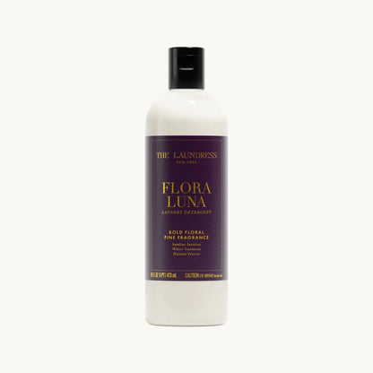 Clear bottle with deep purple and gold-foiled label of Flora Luna detergent on a white background