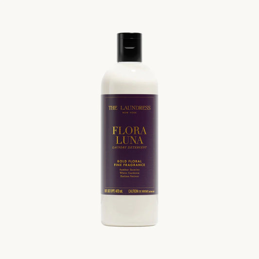Clear bottle with deep purple and gold-foiled label of Flora Luna detergent on a white background