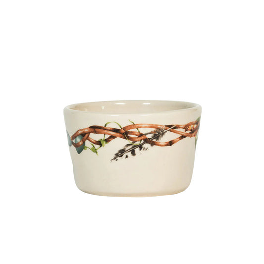 A cream-colored ceramic ramekin with nature-themed design featuring twigs and feathers on a white background