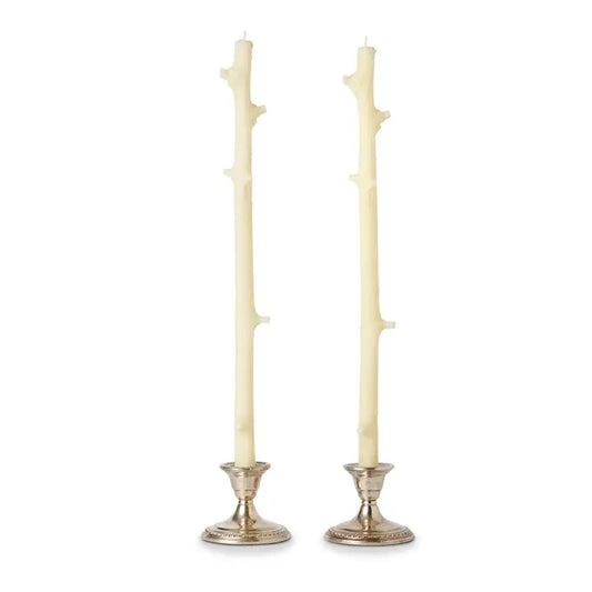 Two off-white twig candle holders with silver bases on a white background