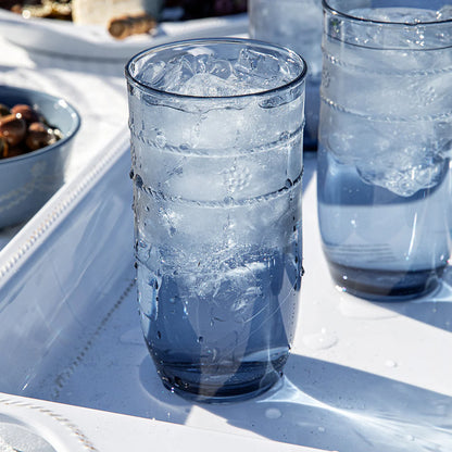Clear-blue tumbler filled with ice on a white serving tray