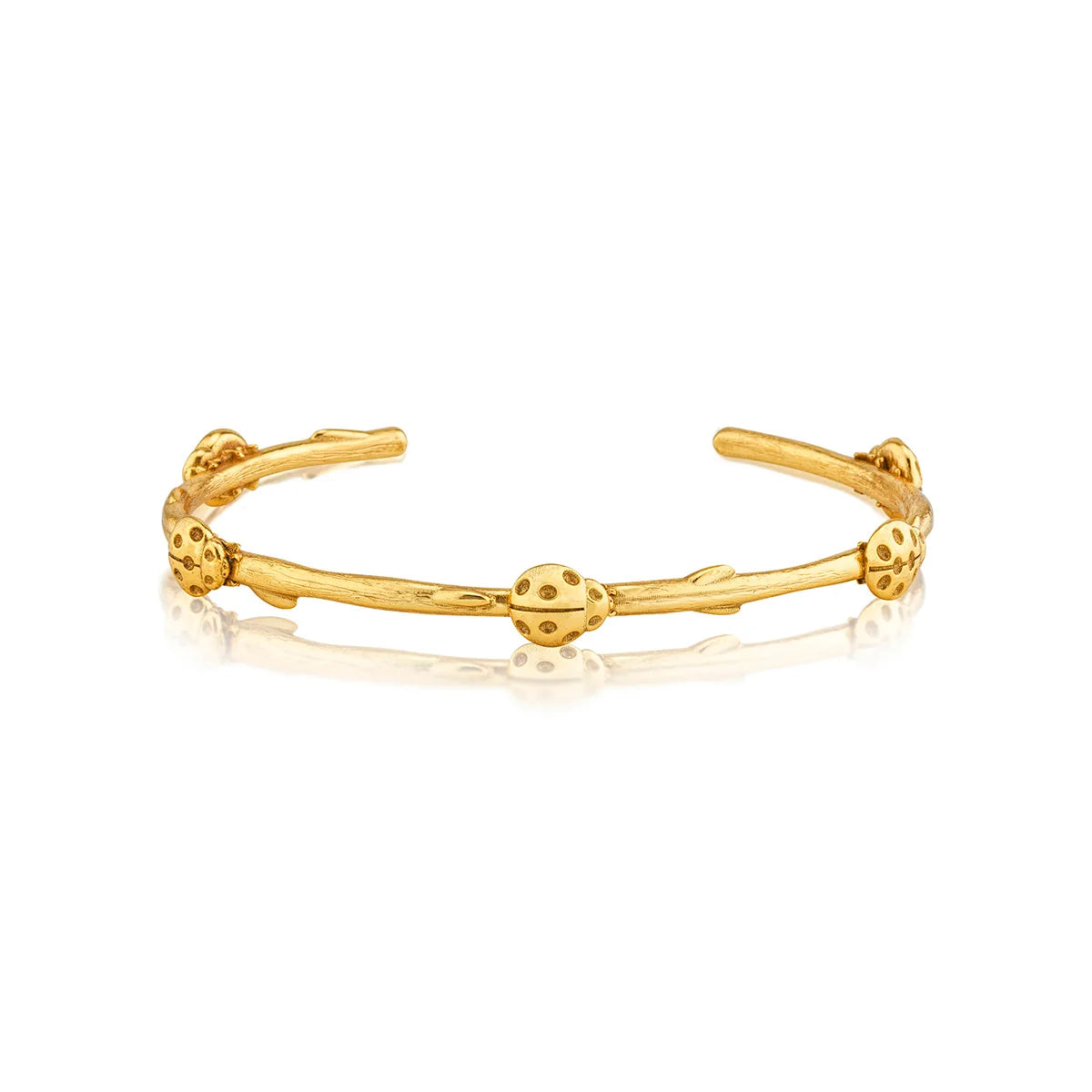 A gold open cuff bracelet featuring ladybugs on a white background.
