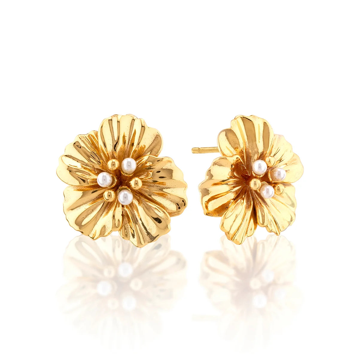 A pair of gold flower-shaped stud earrings with small pearl-like white beads at the center, displayed on a clean white background with a soft reflection below.