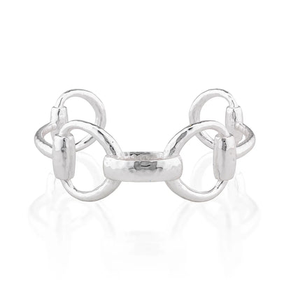 A polished silver horse bit cuff bracelet with a hammered finish and polished links, displayed on a clean white reflective surface.