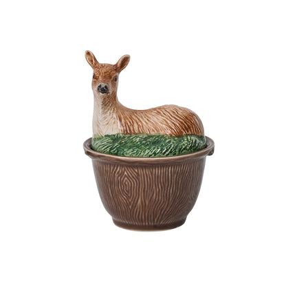 A brown-ceramic, faux bois bowl with a lid with a deer laying in grass.