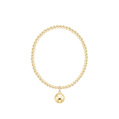Gold beaded bracelet with a round charm on a white background