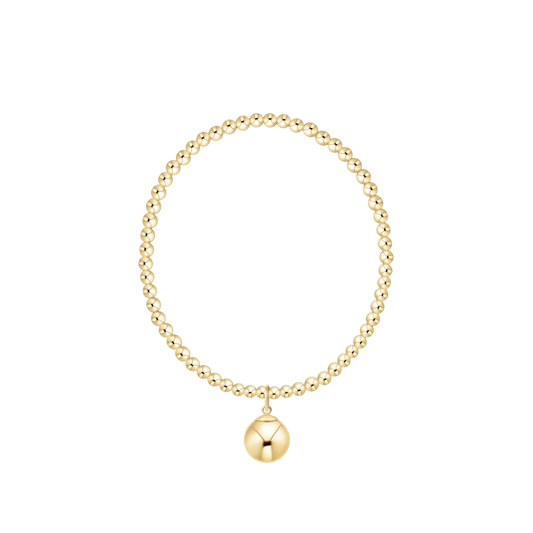 Gold beaded bracelet with a round charm on a white background