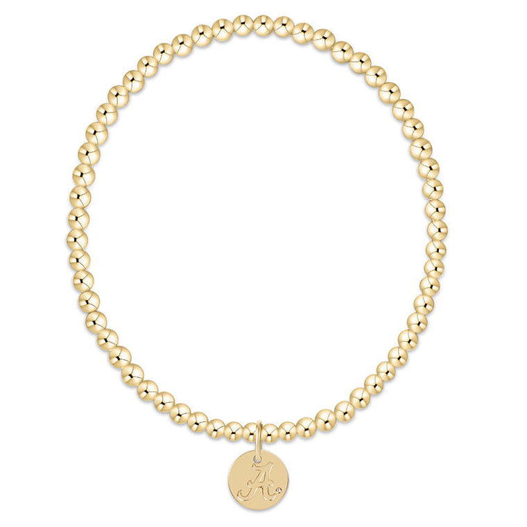 Gold beaded bracelet with a round disc charm on a white background