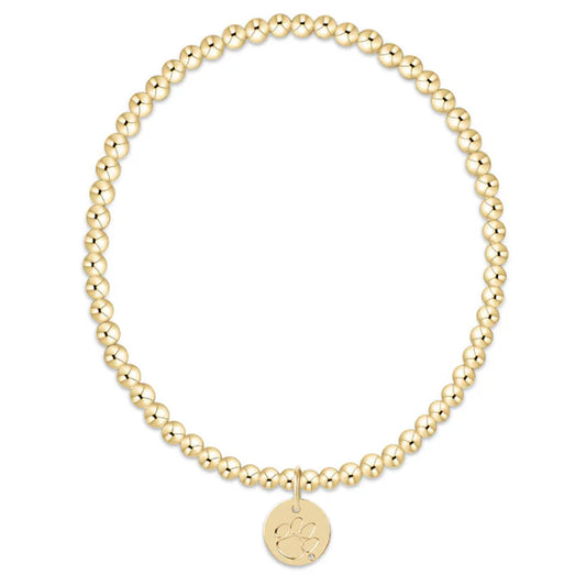 Gold beaded bracelet with a round disc charm on a white background