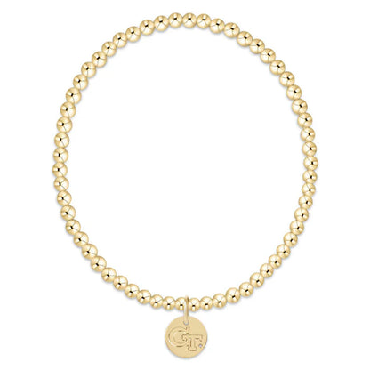 Gold beaded bracelet with a round charm on a white background