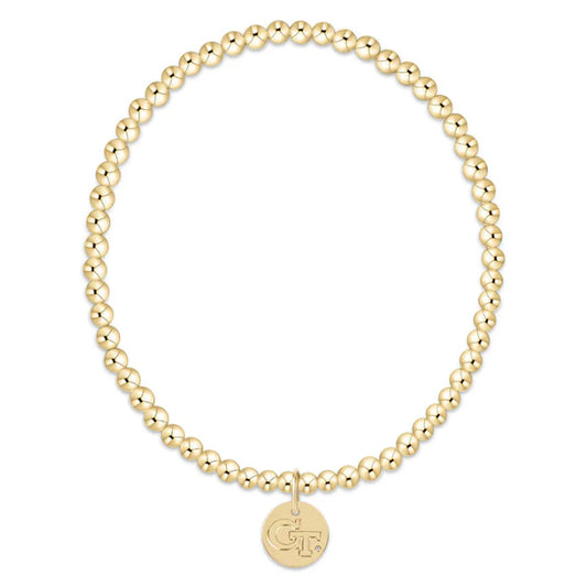 Gold beaded bracelet with a round charm on a white background