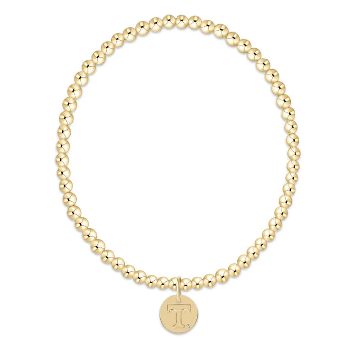 Gold beaded bracelet with a round pendant on a white background