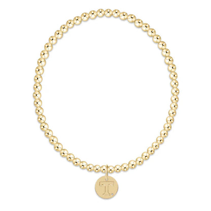 Gold beaded bracelet with a round pendant on a white background