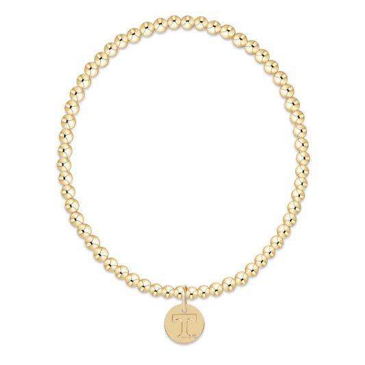 Gold beaded bracelet with a round pendant on a white background