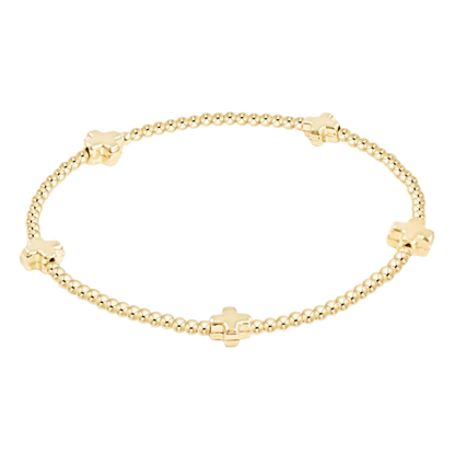 Gold bracelet with cross-shaped beads on a white background