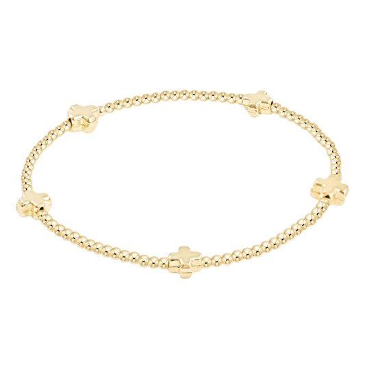 Gold bracelet with cross-shaped beads on a white background