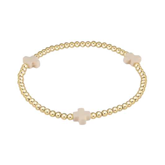 Gold bracelet with beige cross beads on a white background