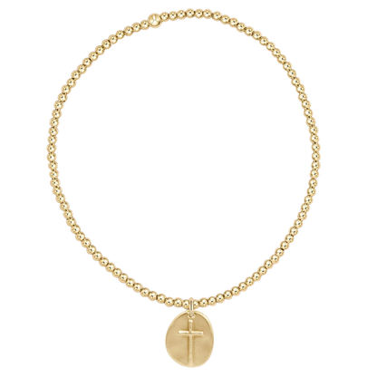 Gold bracelet with a cross pendant on a white background