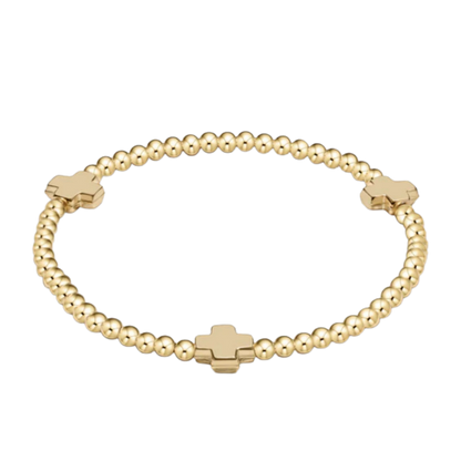 Gold beaded bracelet with cross-shaped beads on a white background