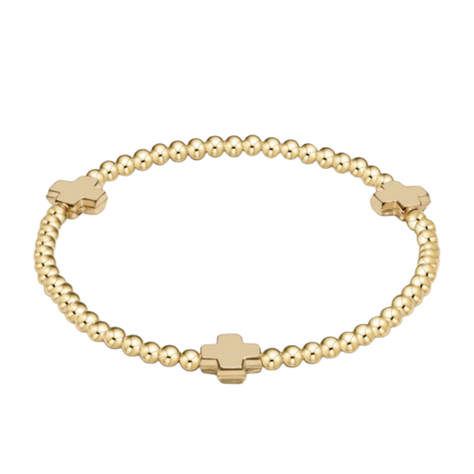 Gold beaded bracelet with cross-shaped beads on a white background