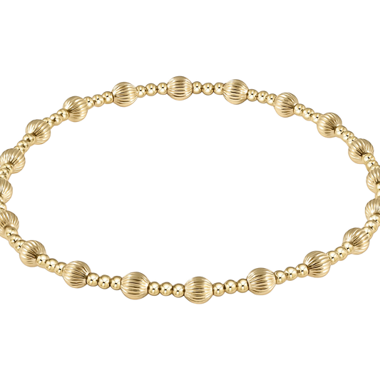 Gold beaded bracelet with textured accents on a white background