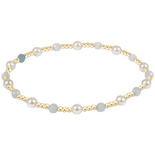 Pearl and gold beaded bracelet on a white background