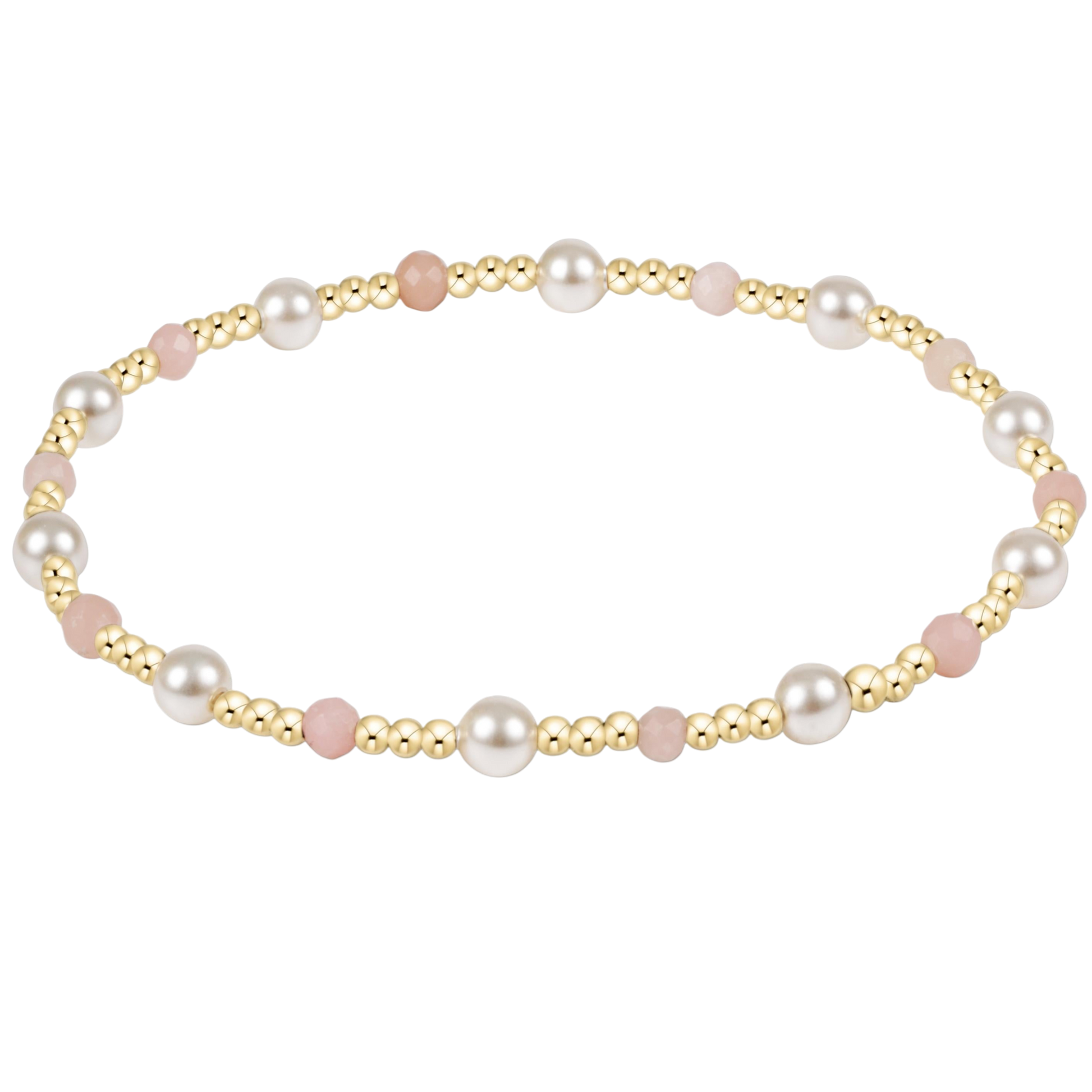 Pearl and gold and pink beaded bracelet on a white background