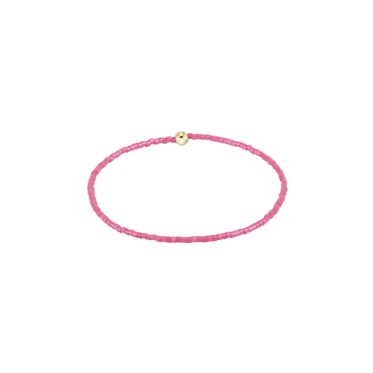 Pink beaded bracelet with a gold clasp on a white background