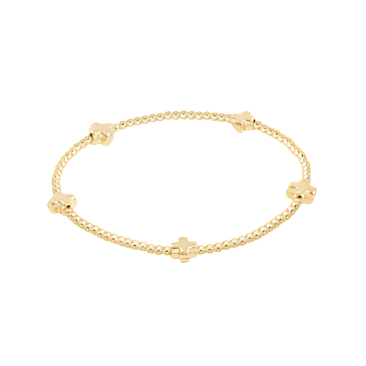 Gold bracelet with small cross beads on a white background