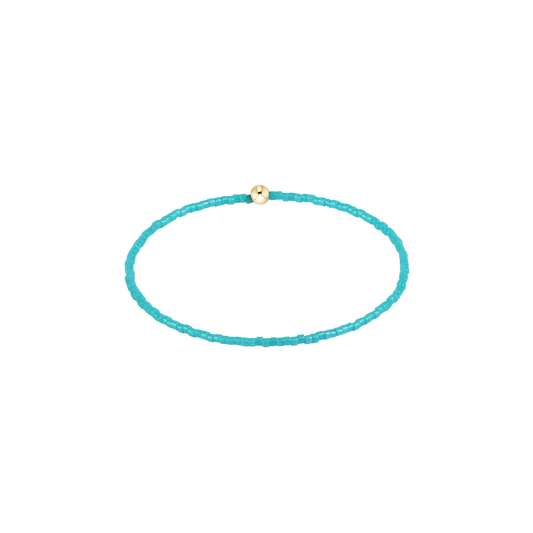 Turquoise beaded bracelet with a gold clasp on a white background