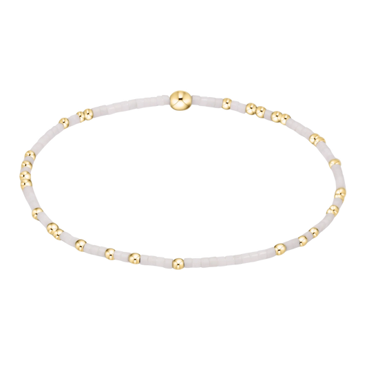 White beaded bracelet with gold accents