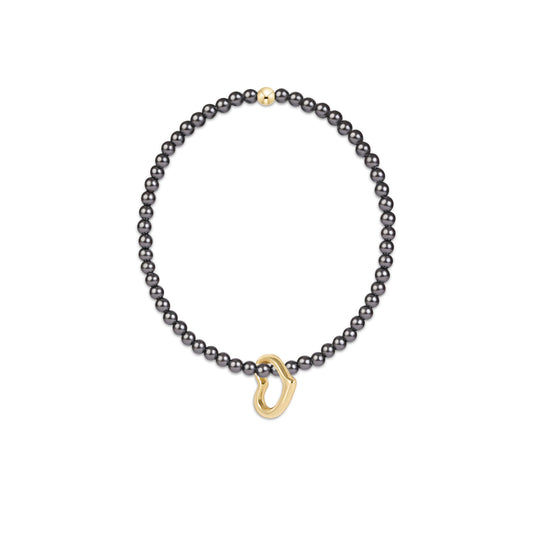 A delicate bracelet featuring a strand of small, dark gray pearls and a polished gold-tone heart-ring clasp.