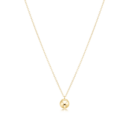Gold necklace with a round bead charm on a white background