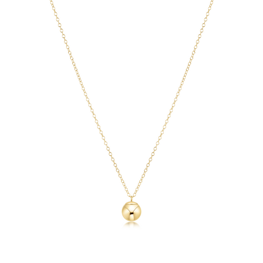 Gold necklace with a round bead charm on a white background