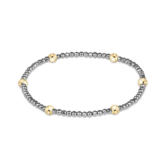 A beaded stretch bracelet featuring dark gray metallic beads and six polished gold accent beads, displayed on a clean white background.