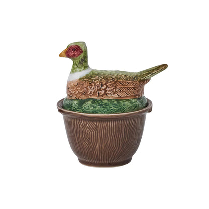 A brown-ceramic, faux bois bowl with a lid with a pheasant laying in grass.