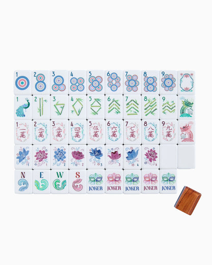 A set of mahjong tiles, featuring traditional Chinese symbols, floral patterns, and characters in blue, pink, green, and purple.